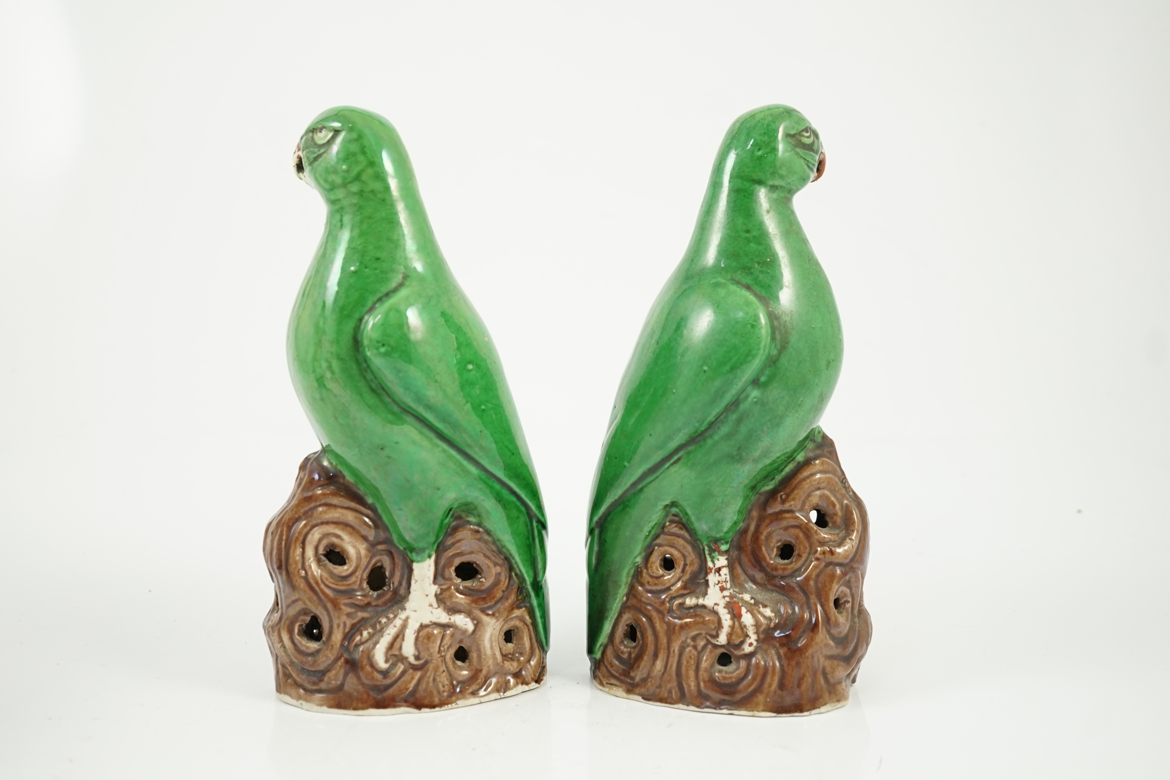 A pair of Chinese green glazed models of parrots, Kangxi period, hairline cracks to one tail feather